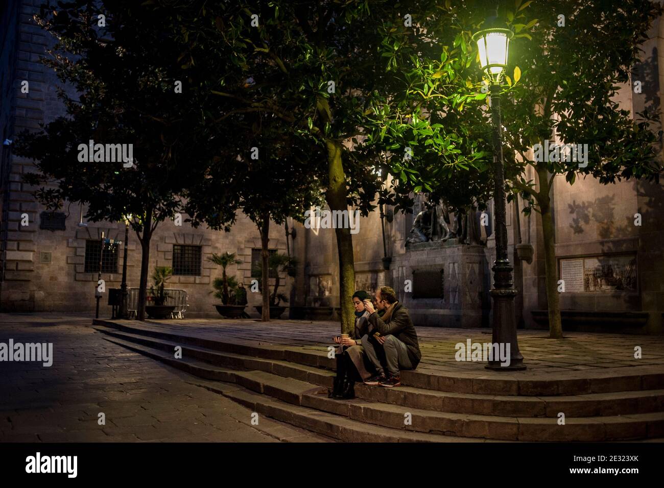 Una pareja se sienta en una pequeña plaza del Barrio Gótico de Barcelona al atardecer. España notificó 35,878 nuevas infecciones por coronavirus y 201 muertes, a medida que el número de la tercera ola aumenta. Foto de stock