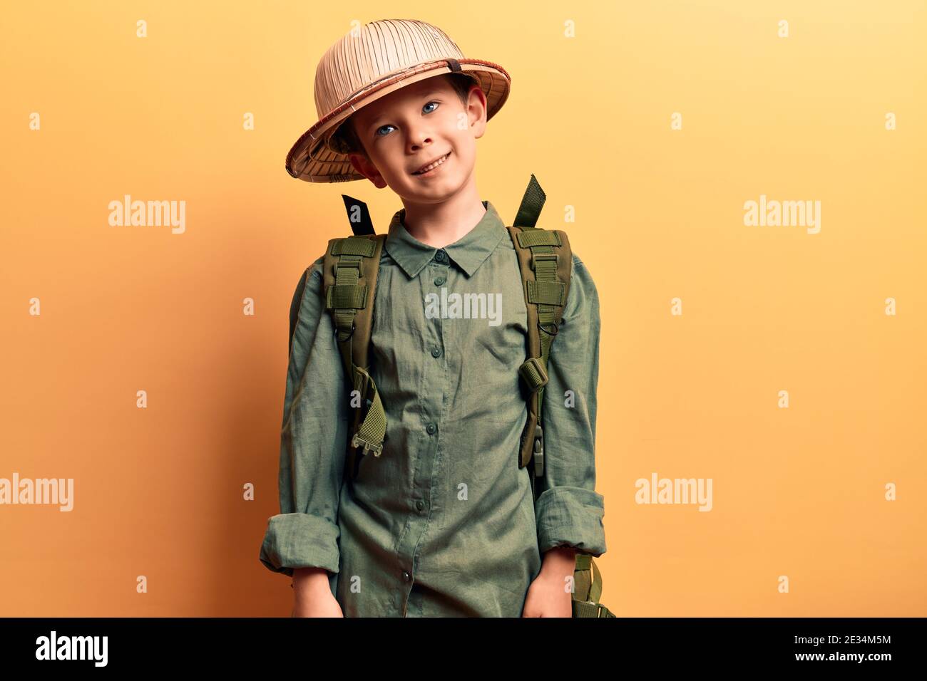 Lindo niño rubio con sombrero explorador y mochila con una sonrisa feliz y  fresca en la cara. Persona afortunada Fotografía de stock - Alamy