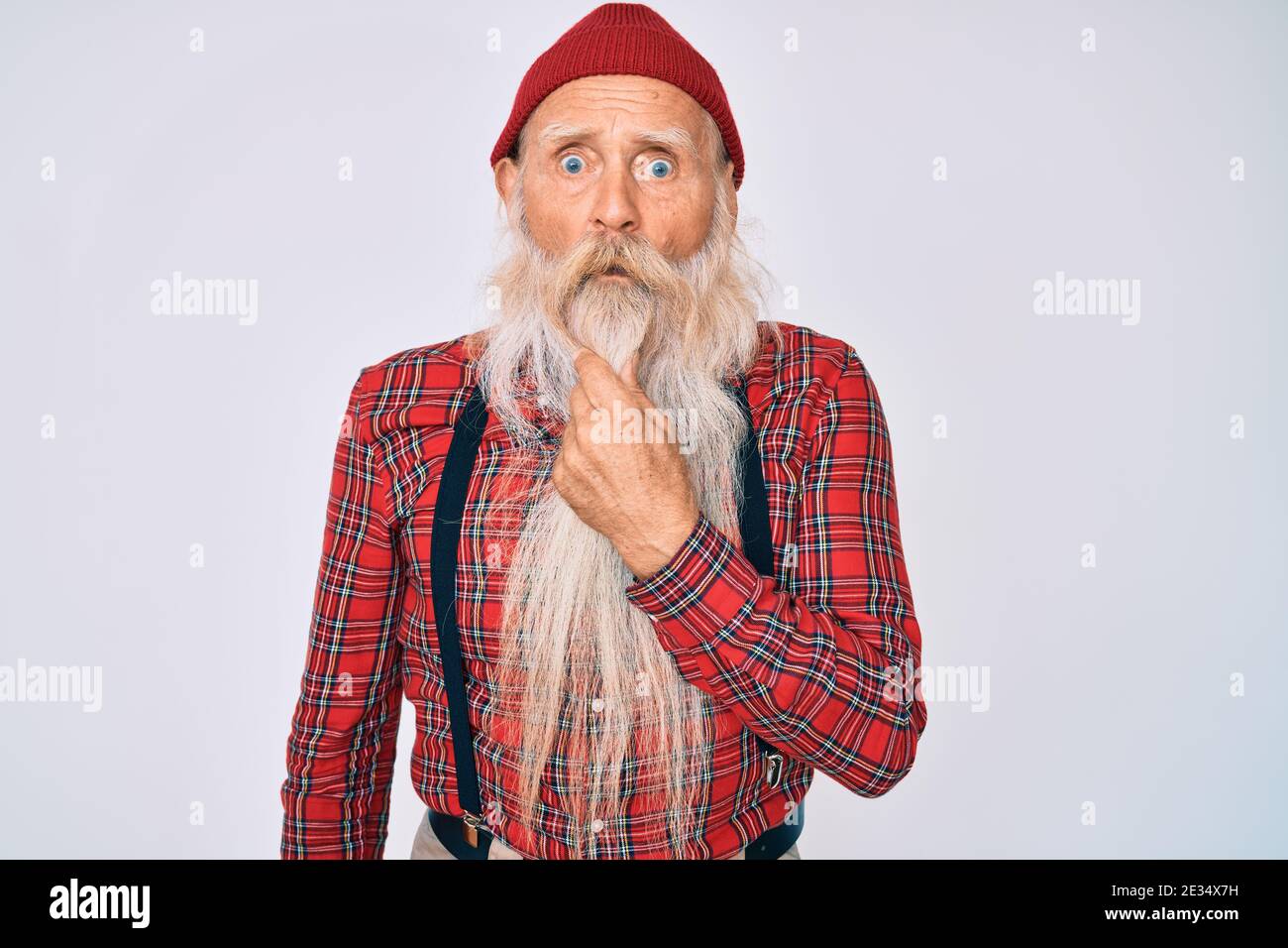 Viejo hombre mayor con pelo gris y barba larga luciendo hipster mirada con  gorro de lana que parece fascinado con incredulidad, sorpresa y expresión  asombrada con Fotografía de stock - Alamy