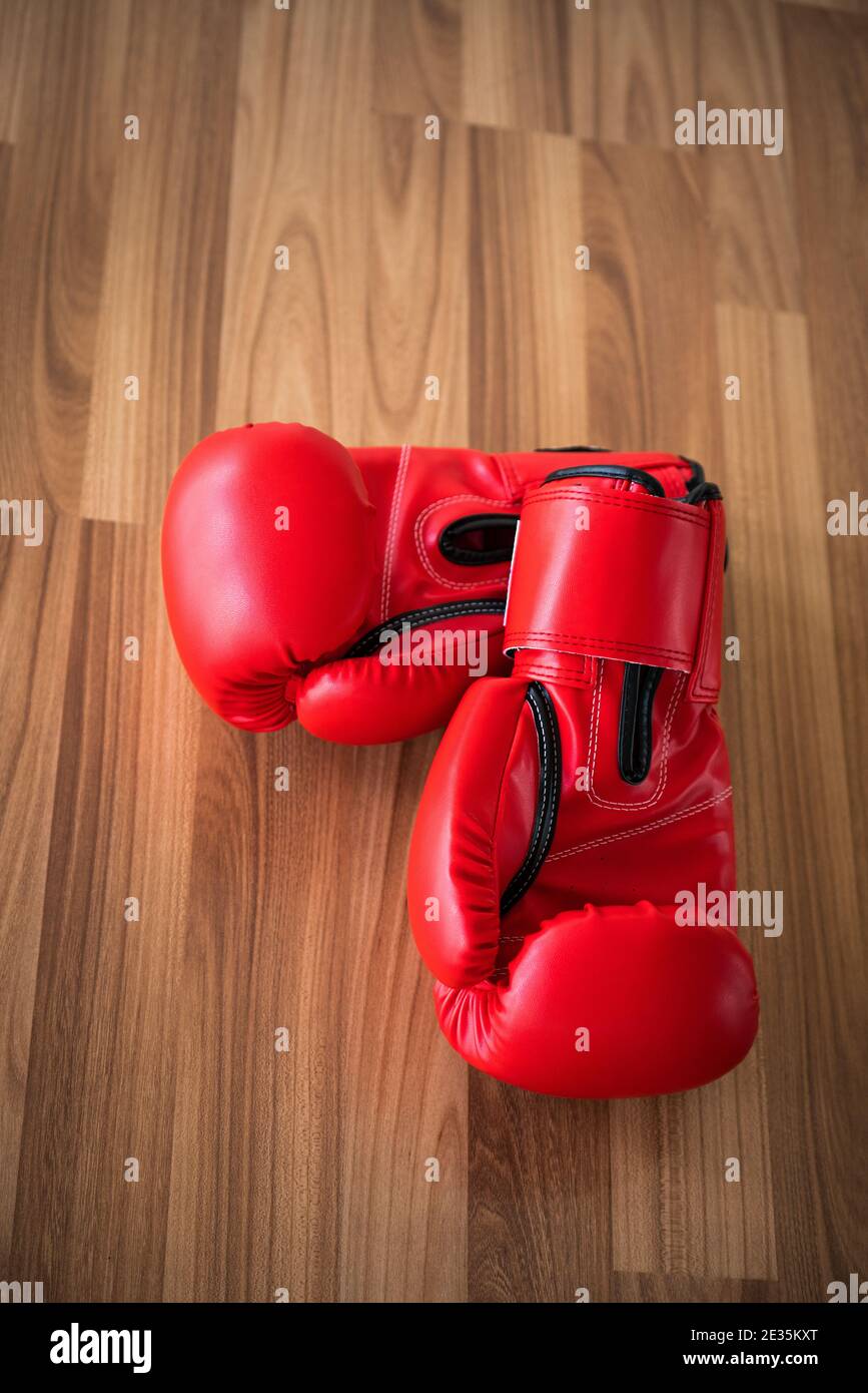 Guantes de boxeo rojo colgado en una pared de madera en un gimnasio  Fotografía de stock - Alamy