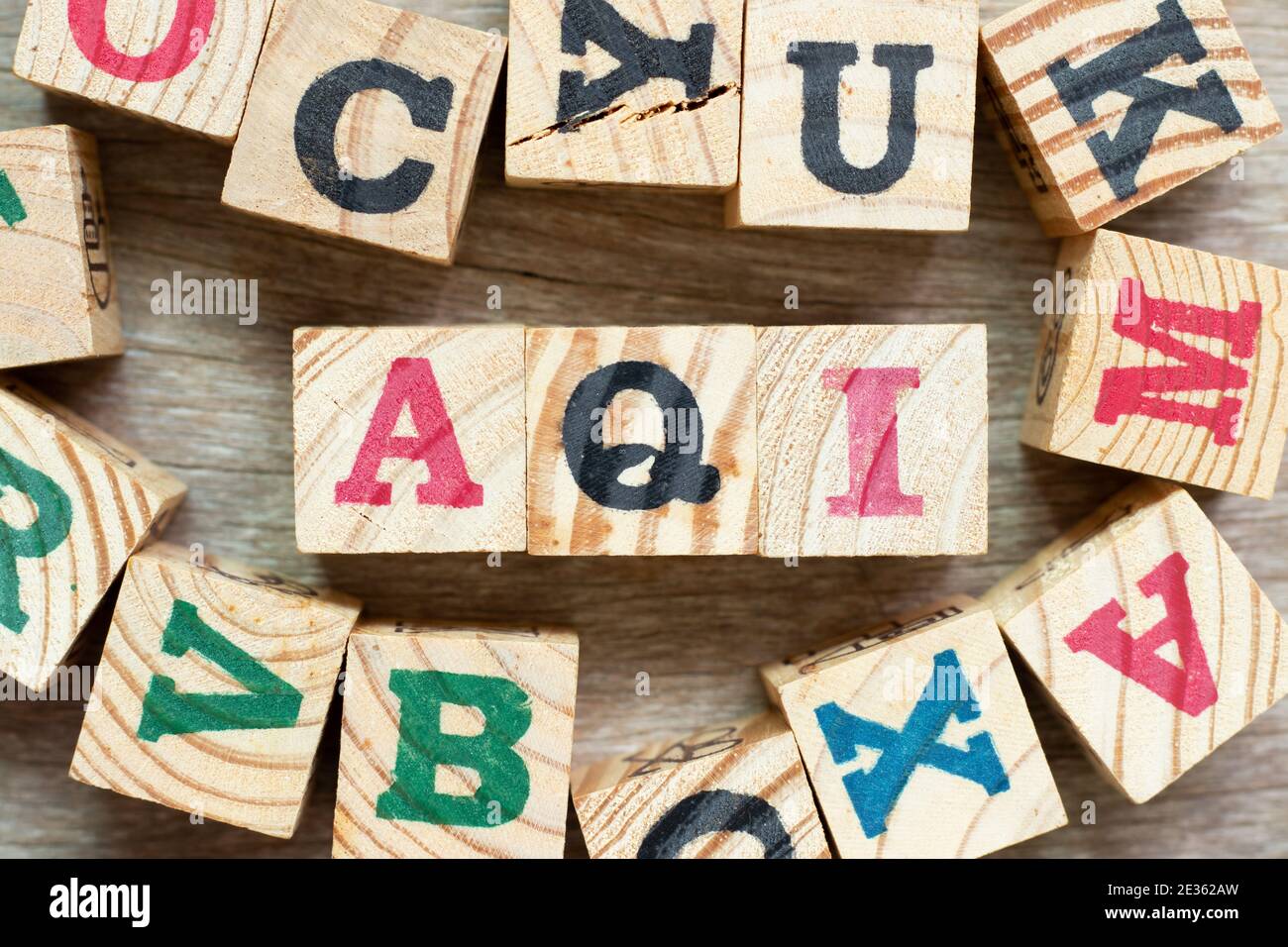 Bloque de letras alfabéticos en la palabra AQI (Abreviatura de índice de calidad del aire) con otro sobre fondo de madera Foto de stock