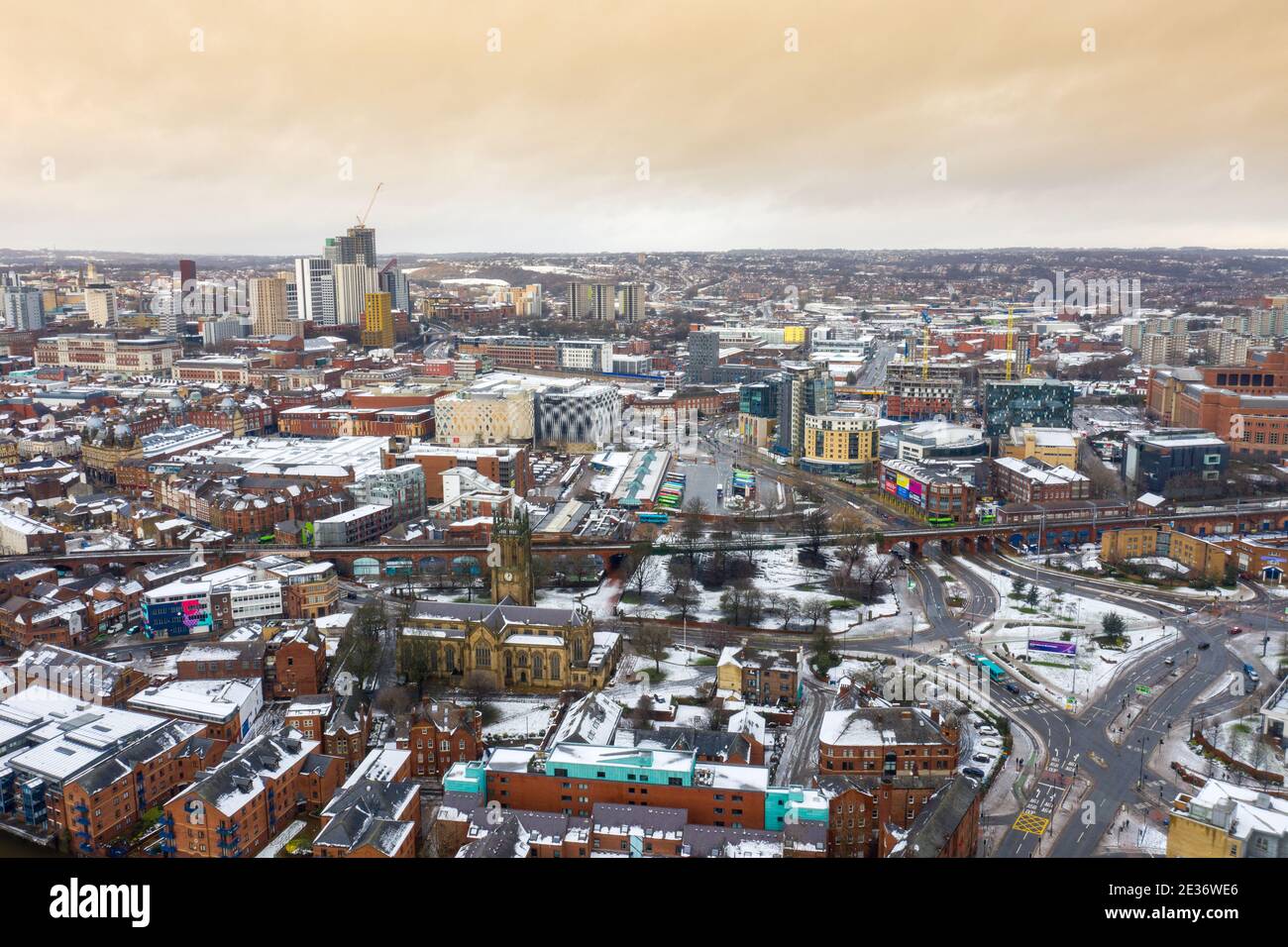 Foto aérea de la zona en el centro de la ciudad de Leeds Conocido como Brewery Wharf mostrando edificios de apartamentos cubiertos de nieve y. la estación de autobuses en el invierno ti Foto de stock