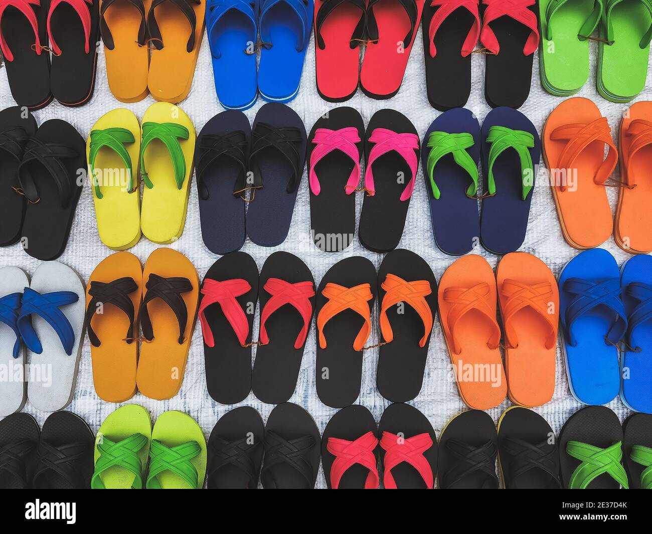 Sandalias de caucho coloridas y cómodas hechas de caucho para la venta en  el mercado local. Filas de hermosas zapatillas multicolor Fotografía de  stock - Alamy