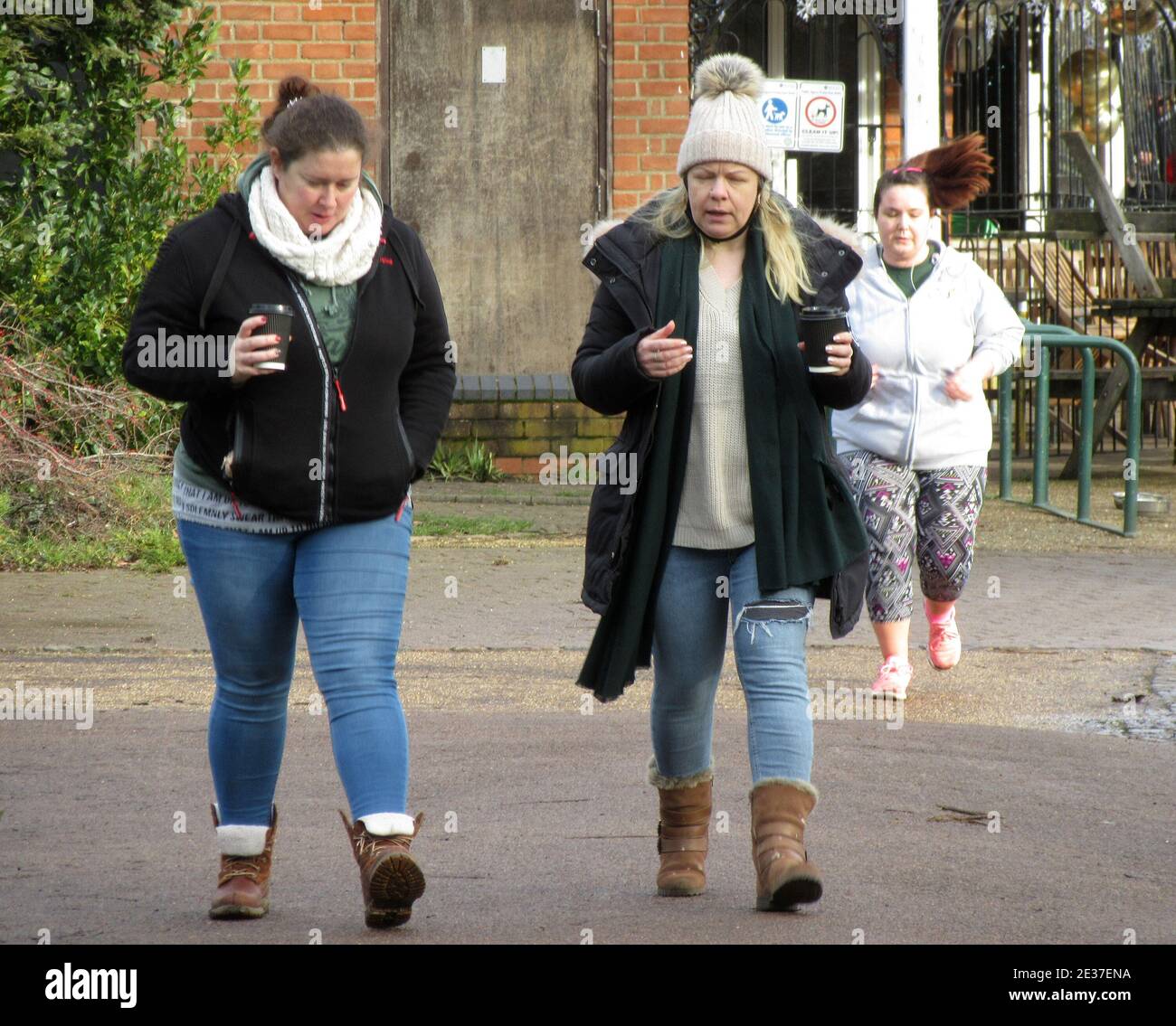 Bedford, Reino Unido. 17 de enero de 2021. Dos mujeres tienen una bebida para llevar que acaba de salir del café del parque a pesar de la declaración del primer Ministro Boris Johnson pidiendo a la gente que se quede en casa este fin de semana, durante el cierre nacional, parece que todavía es más "esencial" hacer cola para un café en el parque. Las familias y los grupos estaban haciendo ejercicio alrededor de Bedford Park hasta que llegaron al café en el centro. La mayoría de la gente parecía estar sosteniendo una taza para llevar mientras caminaba y la cola fuera del café era posiblemente más grande que antes del cierre. Crédito: KEITH MAYHEW/Alamy Live News Foto de stock