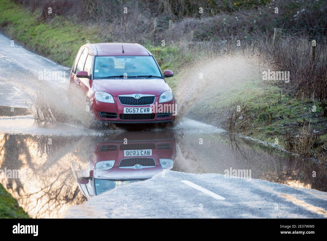 Brighton, 15 de enero de 2021: Un coche que pasa por una carretera inundada en la campiña de Sussex en Saddlescombe, cerca de Brighton Foto de stock