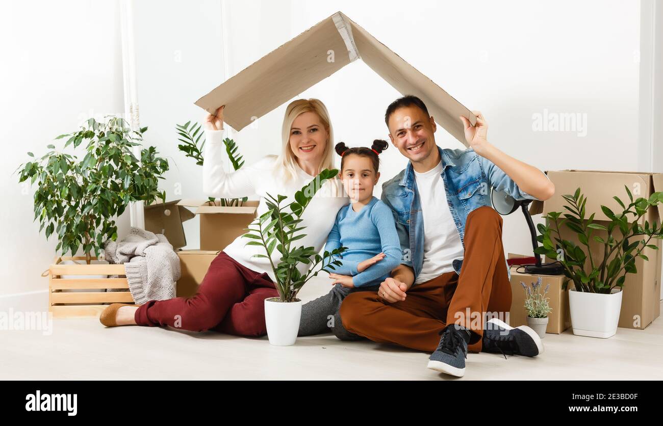 Feliz familia sentada en el suelo de madera. Padre, madre e hijo ...
