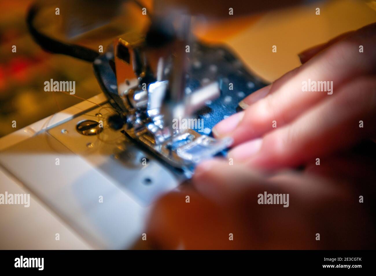 Primer plano de una niña usando una máquina de coser Foto de stock