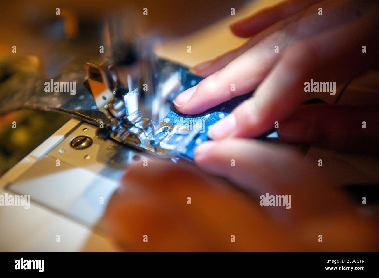 Primer plano de una niña usando una máquina de coser Foto de stock