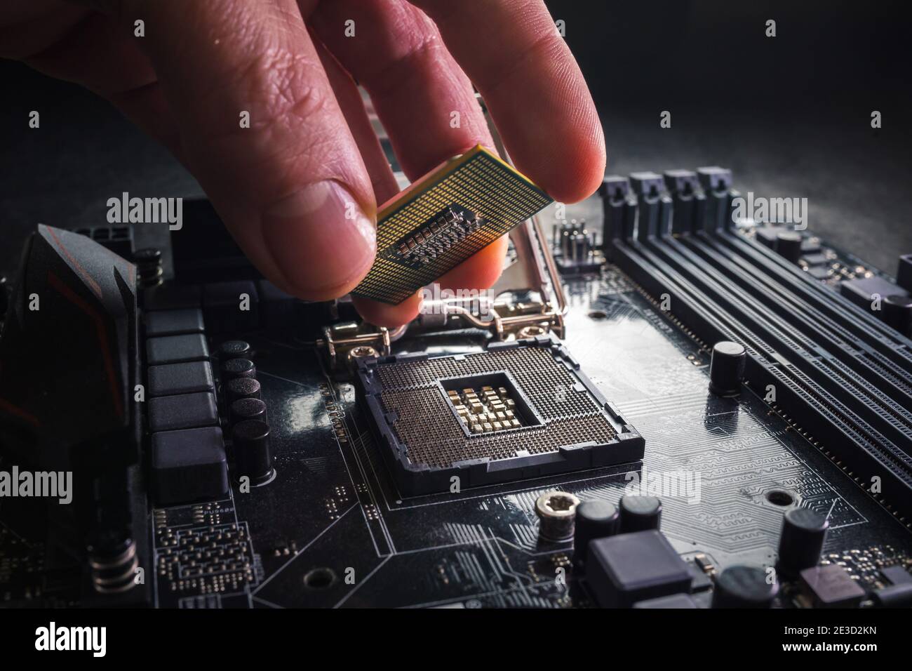 El técnico conecta el microprocesador de la CPU al zócalo de la placa base. Antecedentes del taller. Concepto de actualización o reparación de PC. Foto de stock