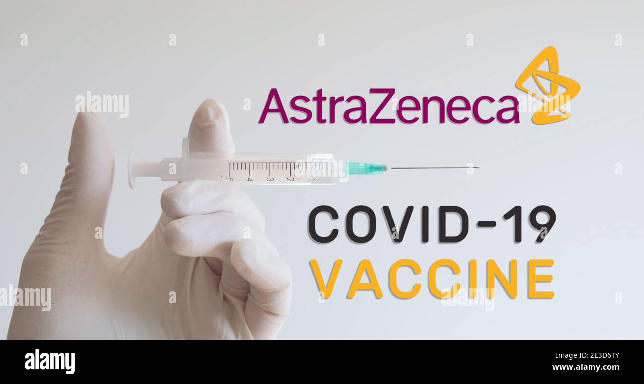 Mano con guante sostiene la jeringa junto al logotipo de AstraZeneca, una de las empresas que desarrollan una vacuna Covid-19 (Coronavirus). Viena, Austria - Enero de 18 Foto de stock