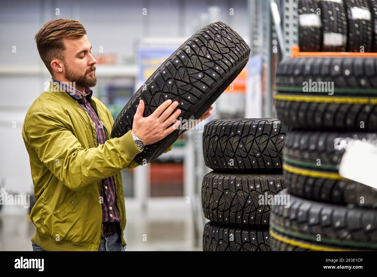 el hombre que elige el neumático de coche en la tienda, el hombre caucásico  quiere comprar ruedas para el automóvil, examinar el surtido Fotografía de  stock - Alamy