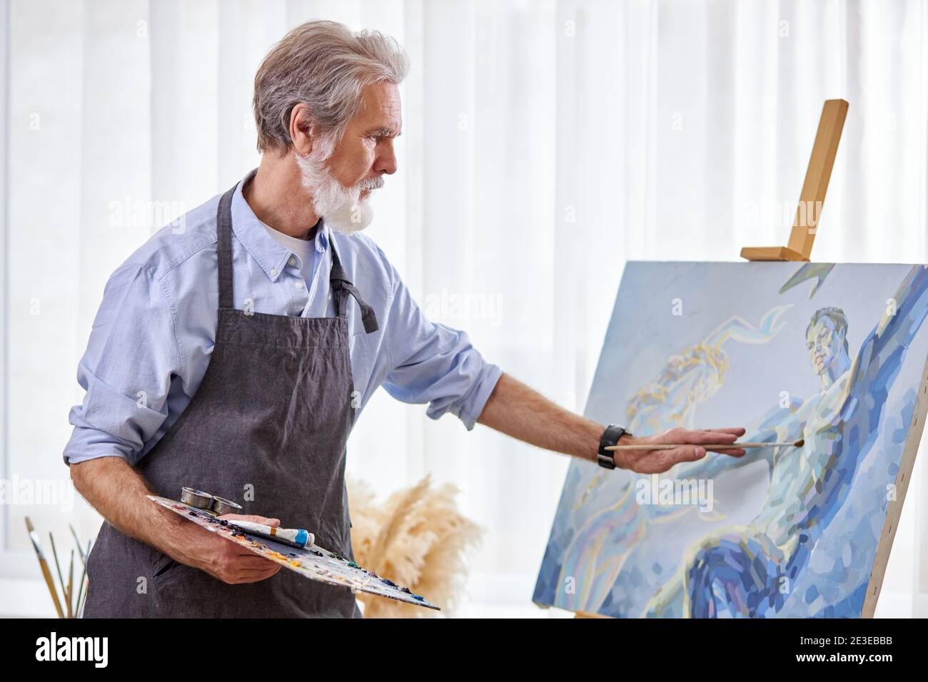 la pintura de artistas mayores en caballete, lienzo, pintor profesional  inteligente disfruta del arte Fotografía de stock - Alamy