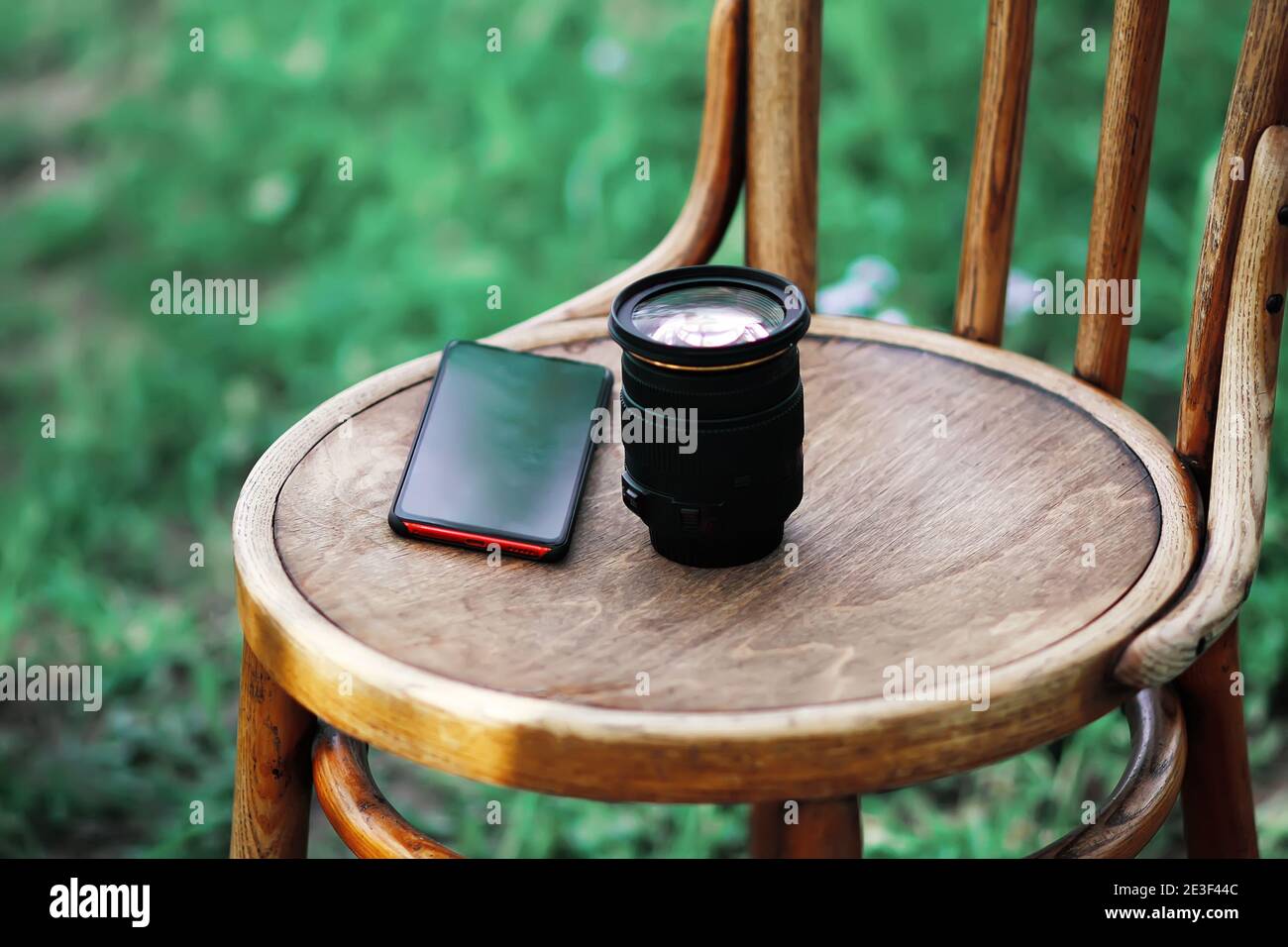 Lente de cámara digital y teléfono móvil en el antiguo vienne sillas al aire libre Foto de stock