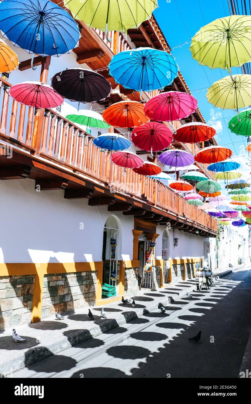 Calle colorida con sombrillas multicolores en la ciudad amurallada de Cartagena, Colombia Foto de stock