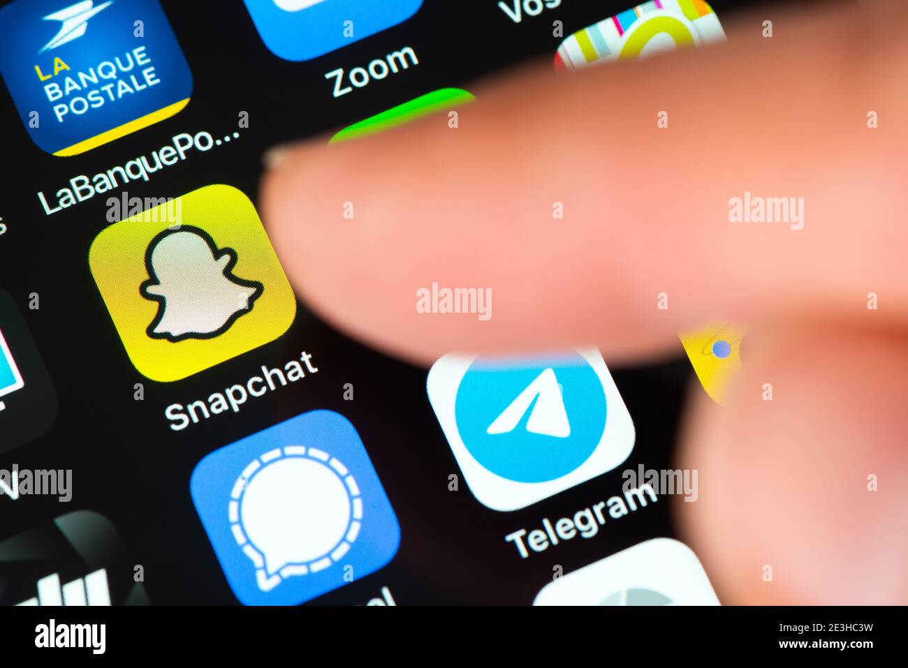 El dedo señala el icono de la aplicación Snapchat en la pantalla de Apple iPhone. Snapchat es una aplicación de mensajería multimedia desarrollada por Snap Inc Foto de stock