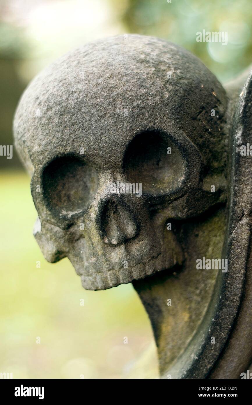 Cráneo humano de piedra en la tumba escocesa en el cementerio de la ciudad de Edimburgo Foto de stock