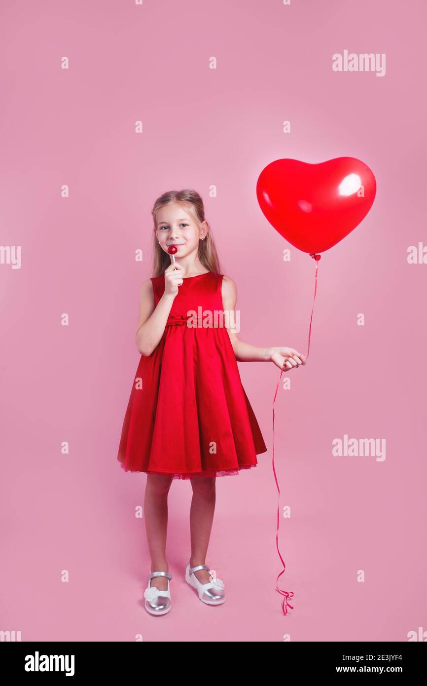 Día de San Valentín. Niña en vestido rojo con forma de corazón globo de  aire sobre fondo rosa Fotografía de stock - Alamy