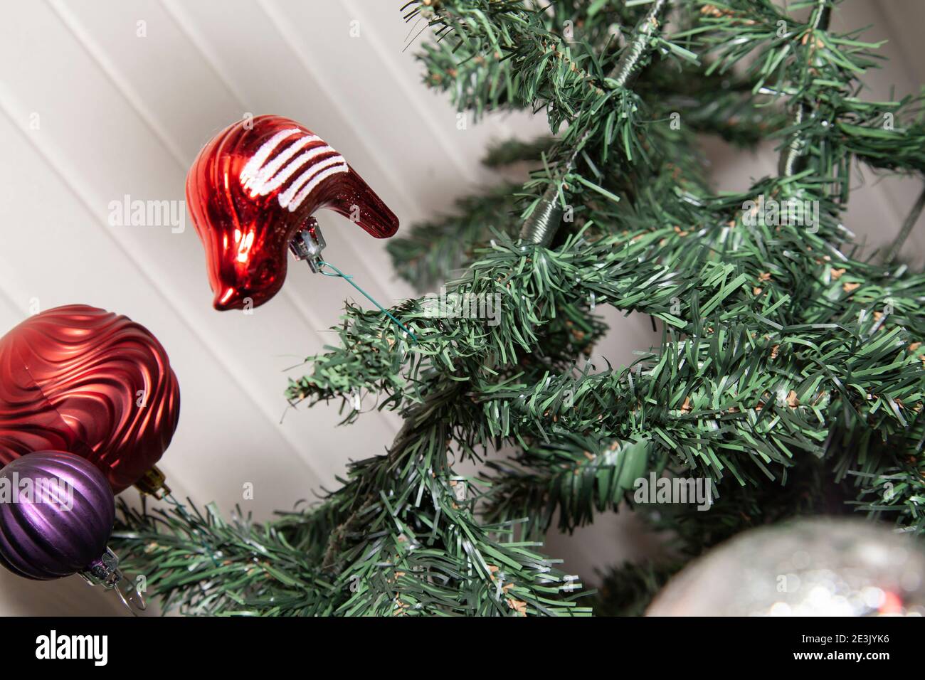Decoración de paloma roja y blanca colgando cerca de rojo y púrpura globos  en un árbol de Navidad artificial Fotografía de stock - Alamy