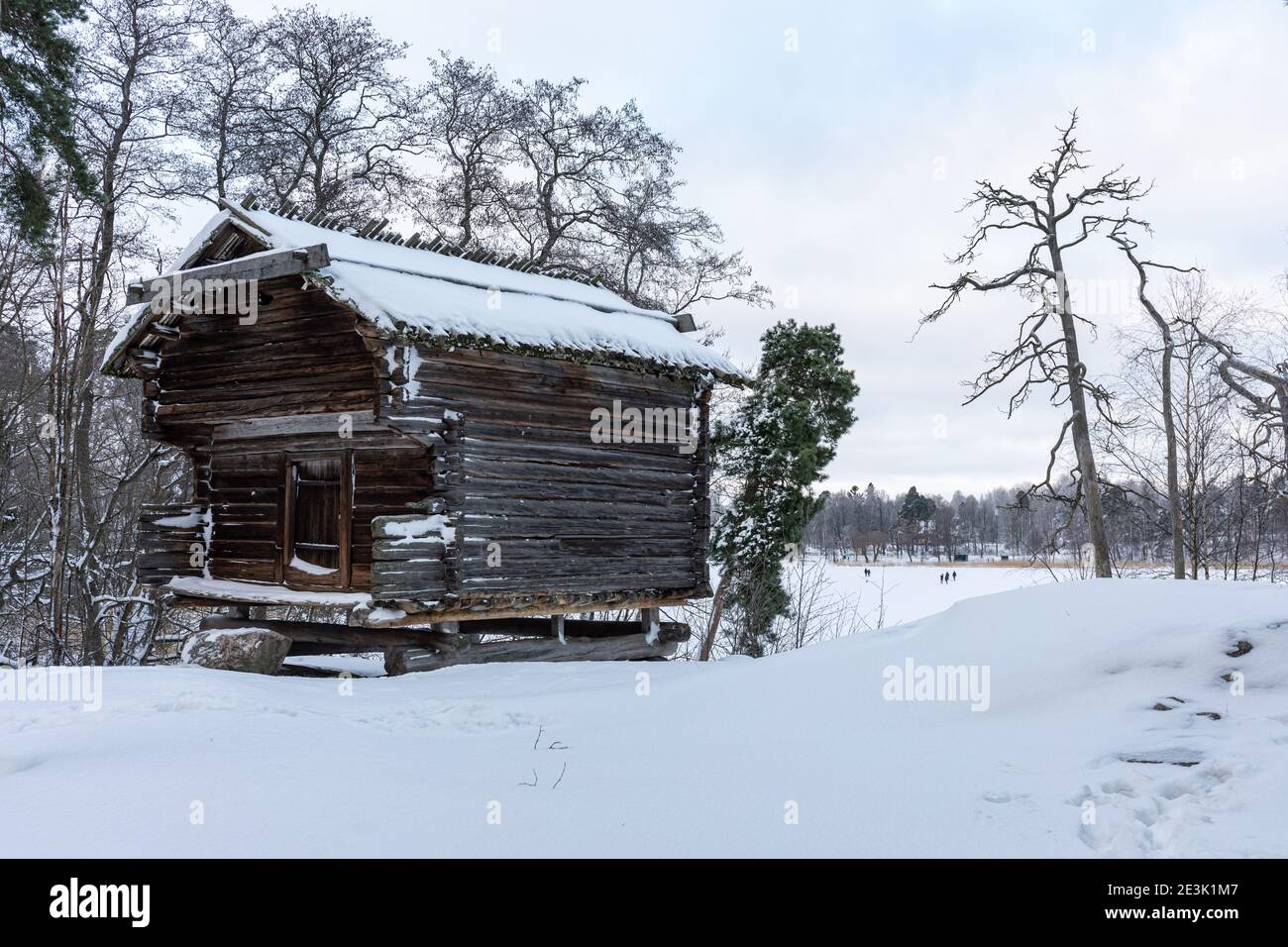 Granero de troncos cubierto de nieve de 1600 en el Museo al Aire libre de Seurasaari durante el invierno en Helsinki, Finlandia Foto de stock
