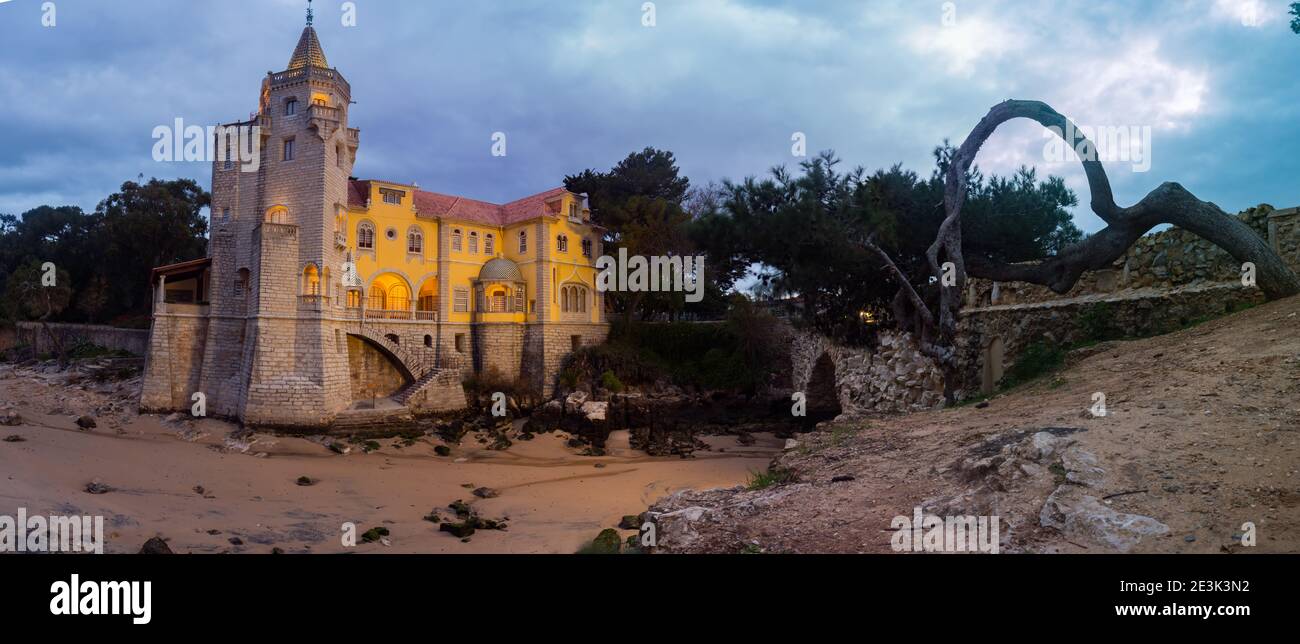 Hermoso edificio del museo - Condes de Castro Guimarães - durante el amanecer con iluminación nocturna, Vista panorámica. Cascais, Portugal Foto de stock
