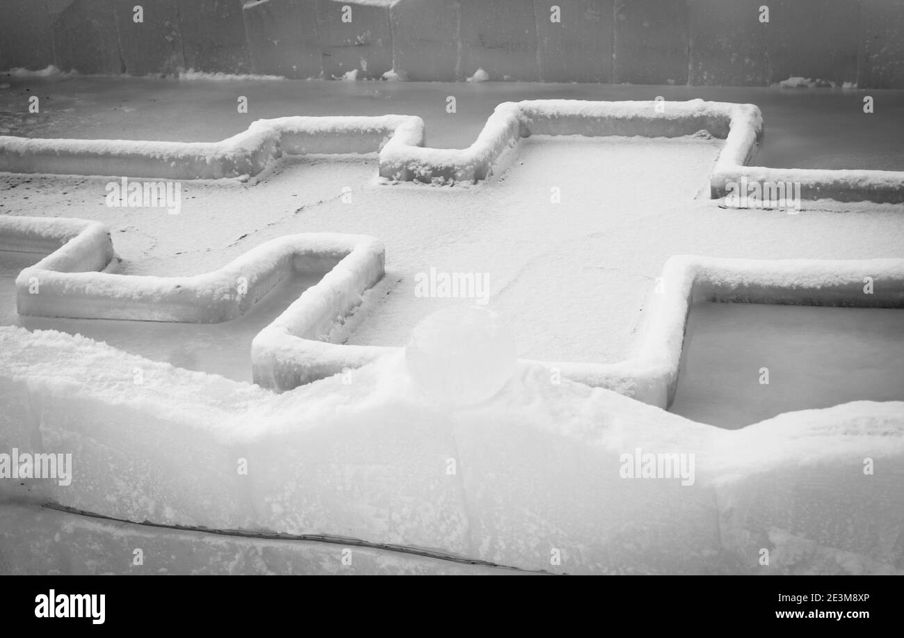 Fuente para sumergirse en un agujero de hielo para el bautismo de cristo y la escultura de hielo en forma de an ángel y una cruz Foto de stock