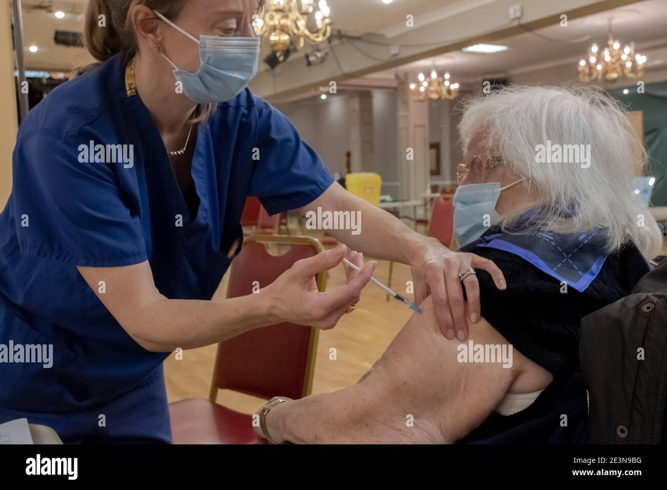 Una anciana recibe la primera dosis de la vacuna Pfizer/BionTec Covid-19 en un centro de vacunación NHS en Frimley Green, Surrey Foto de stock