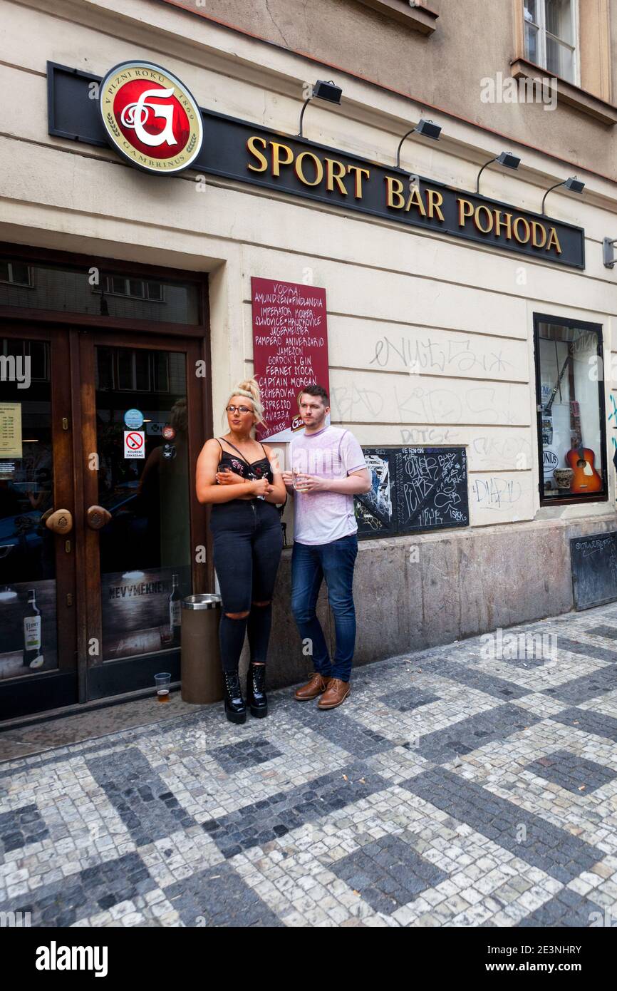 Hombre y mujer fuera del bar deportivo Pohoda, calle Dlouha Praga Foto de stock