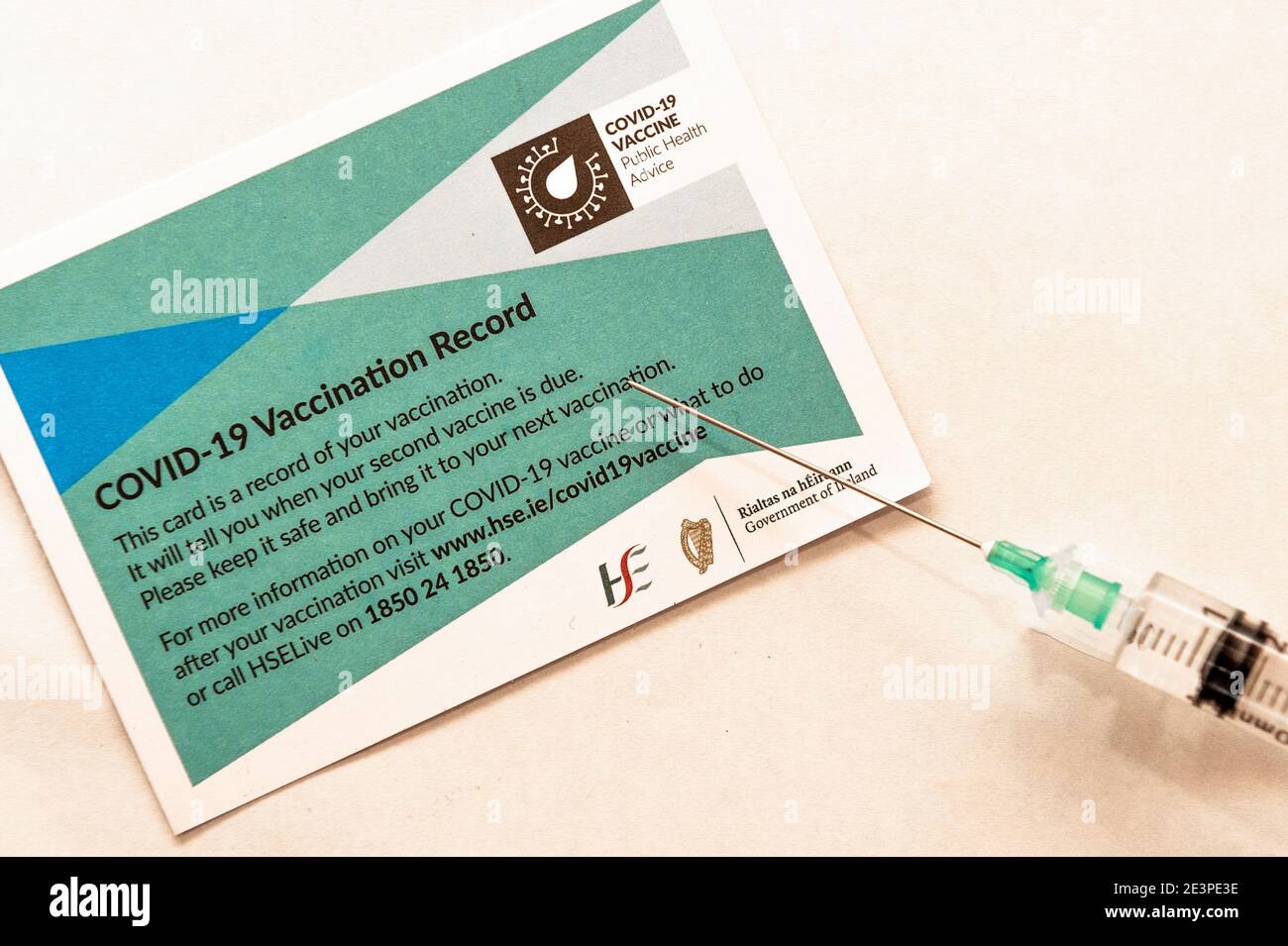 Jeringa y tarjeta de registro de vacunación como parte del Vacuna COVID-19 sobre fondo blanco Foto de stock