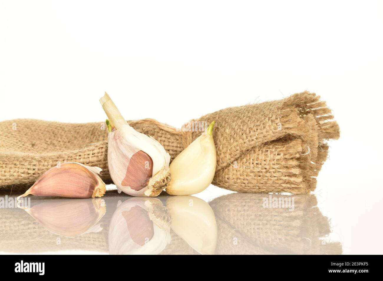 Unas cuantas cabezas maduras picantes orgánicas enteras de ajo y unos pocos  clavos yacen en tela de yute sobre un fondo blanco Fotografía de stock -  Alamy
