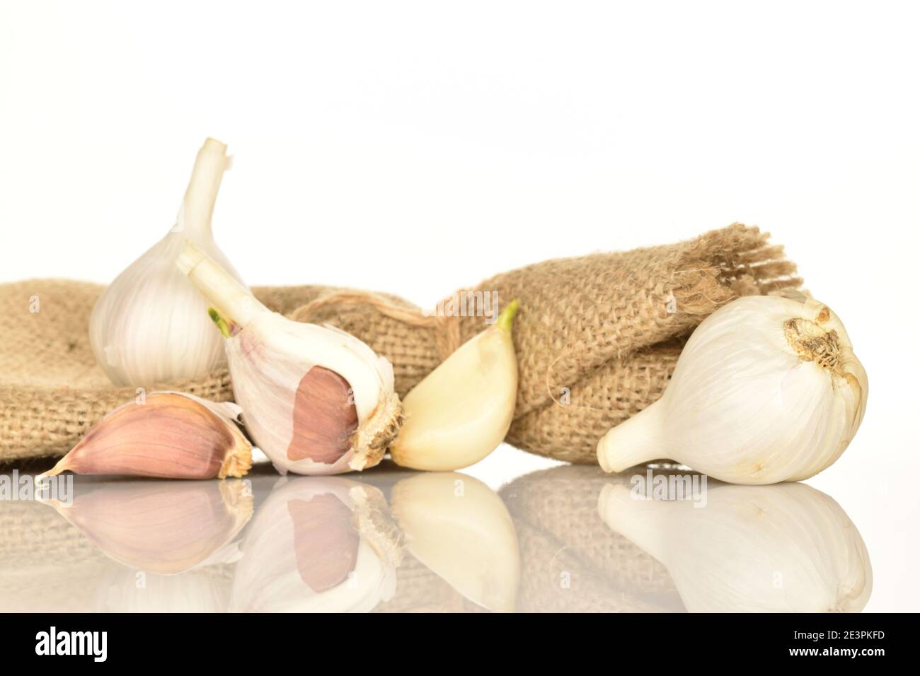 Unas cuantas cabezas maduras picantes orgánicas enteras de ajo y unos pocos  clavos yacen en tela de yute sobre un fondo blanco Fotografía de stock -  Alamy