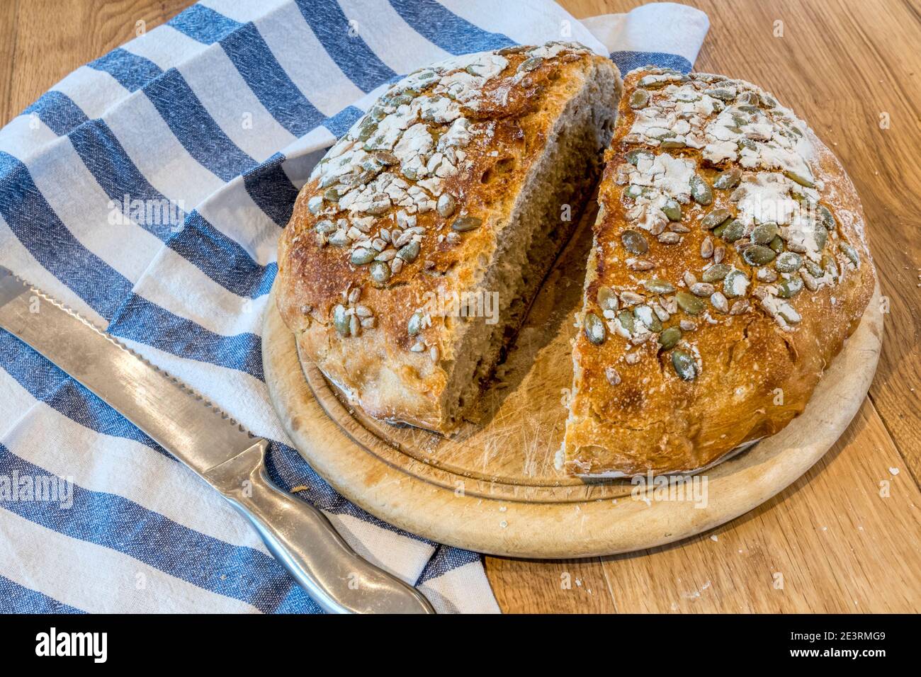 Pan casero de masa de calabaza, cortado en tabla de pan en la mesa de la cocina. Foto de stock