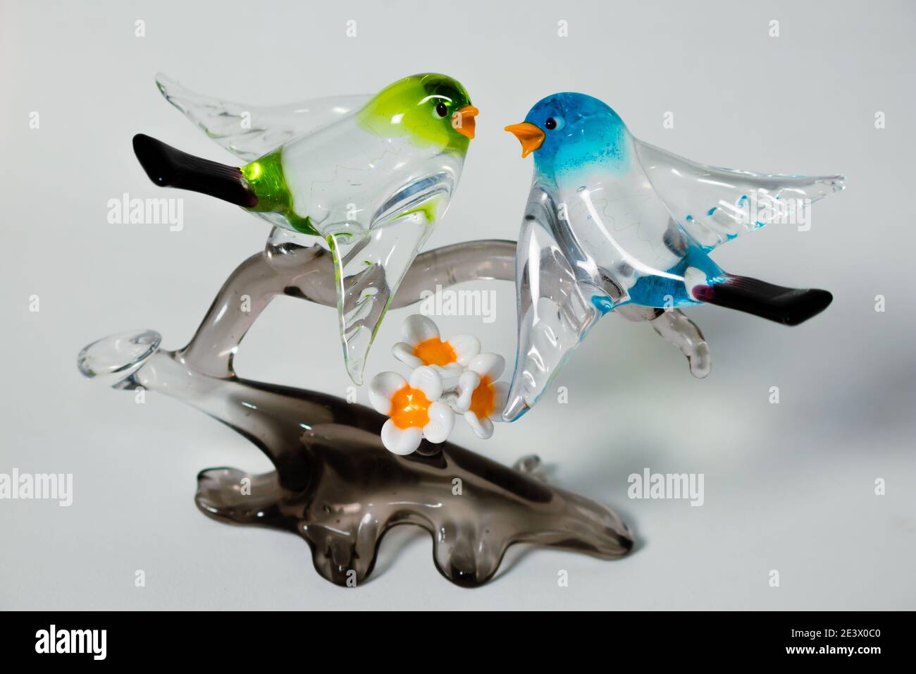 Un par de pájaros de cristal sobre una rama de cristal gris hecha en  Murano, Italia. Fondo blanco Fotografía de stock - Alamy