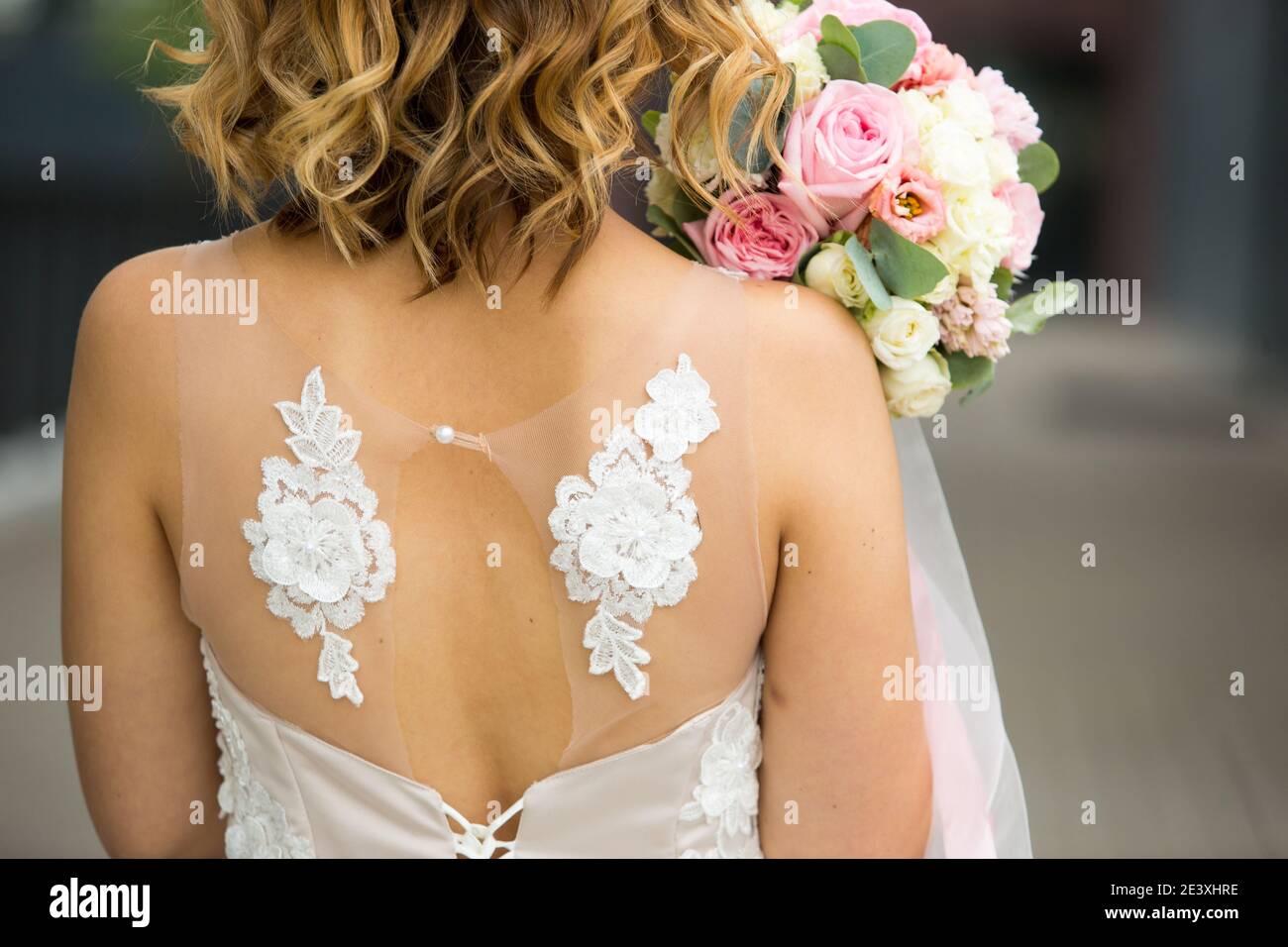 Espalda de la novia en un primer plano blanco vestido de boda. Ramo de  rosas de novia en colores pastel, rizos. Alas de ángel en la decoración del  vestido. BRI Fotografía de