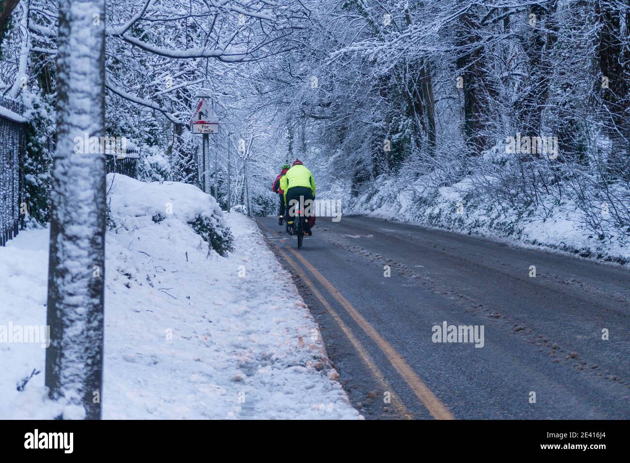 Ciclismo a lo largo de un camino cubierto de nieve Foto de stock
