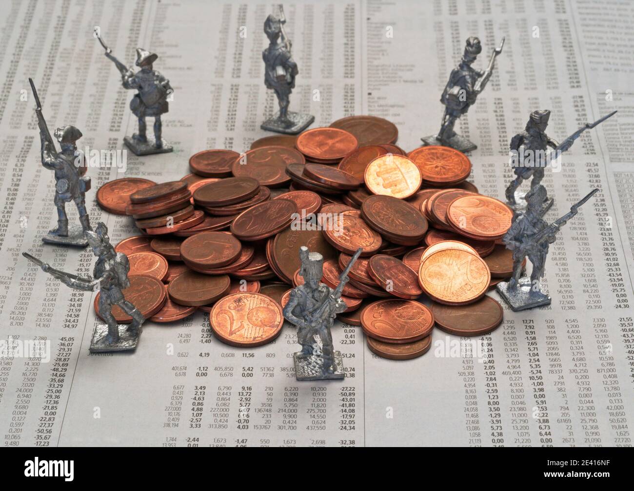 lideran a los soldados defendiendo una pila de monedas de euro en la página financiera del periódico que muestra los precios de las acciones Foto de stock