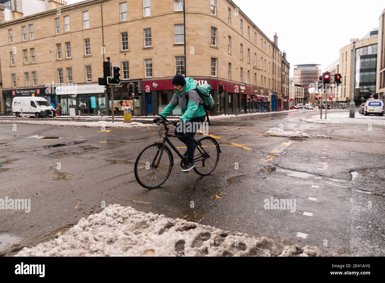 Deliveroo ciclista de entrega, en bicicleta de la manera equivocada en el centro de la ciudad de Edimburgo, Escocia, Reino Unido. Foto de stock