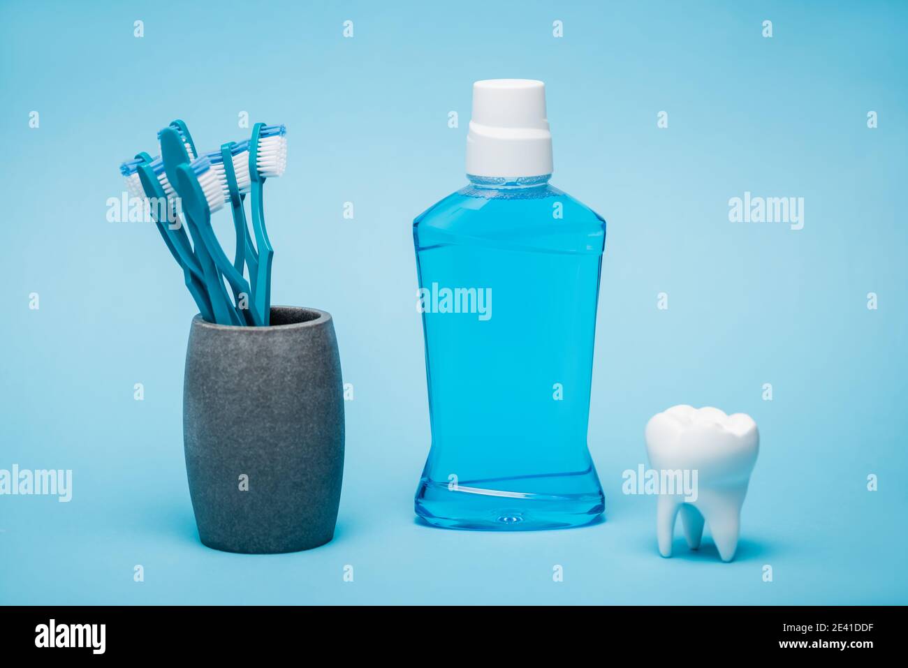 Cepillos de dientes, enjuague bucal y modelo blanco de diente sobre fondo  azul Fotografía de stock - Alamy