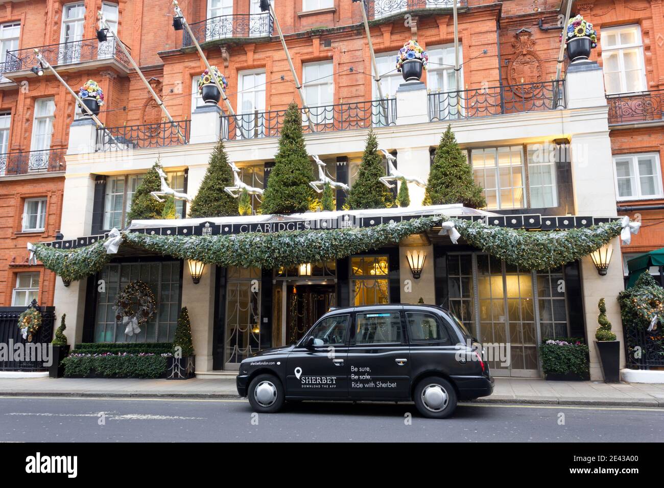 Black cap taxi llega fuera del hotel Claridge's en Mayfair Londres westend Foto de stock