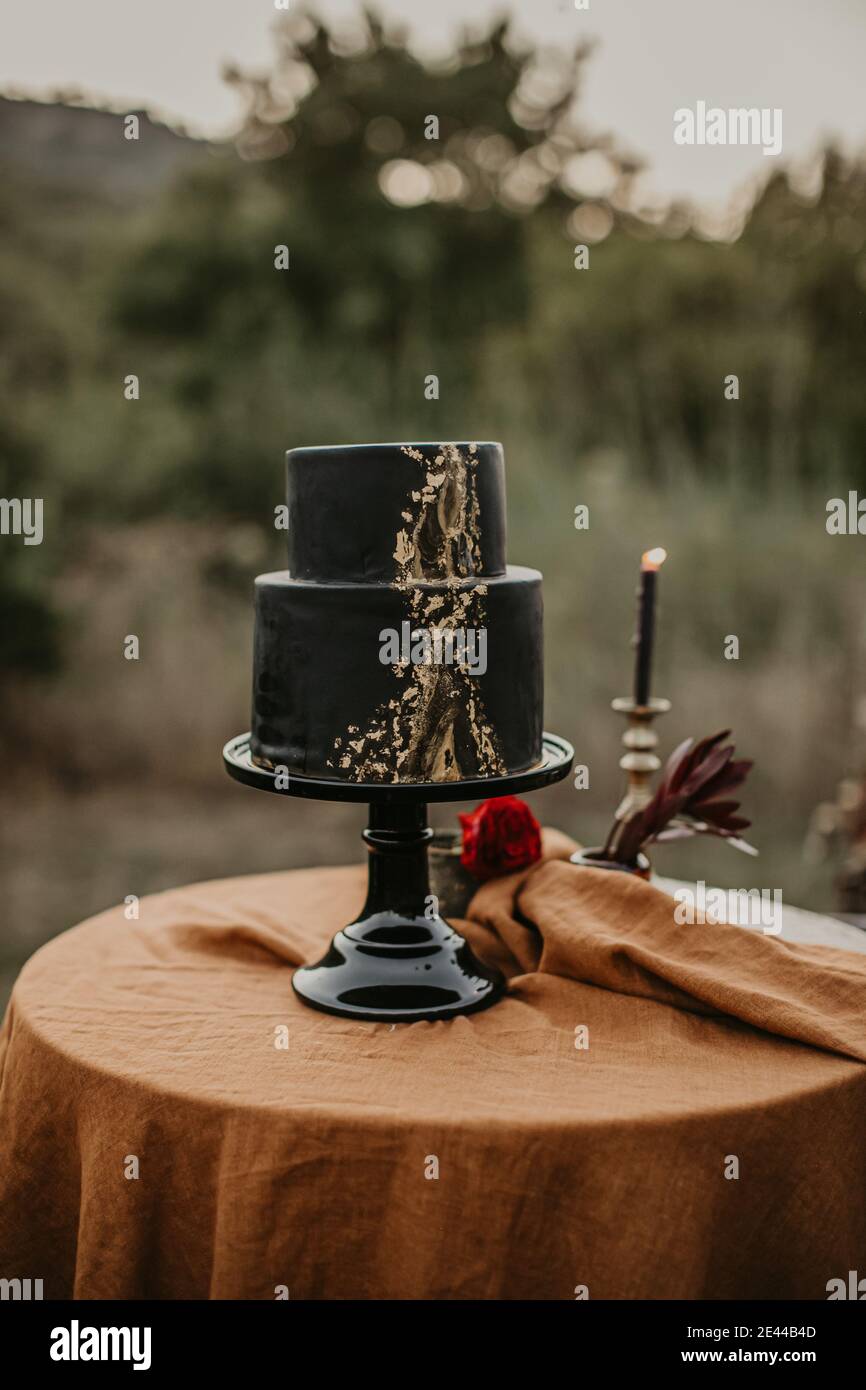 Pastel de boda negro creativo servido en mesa redonda en el jardín para la  celebración festiva Fotografía de stock - Alamy