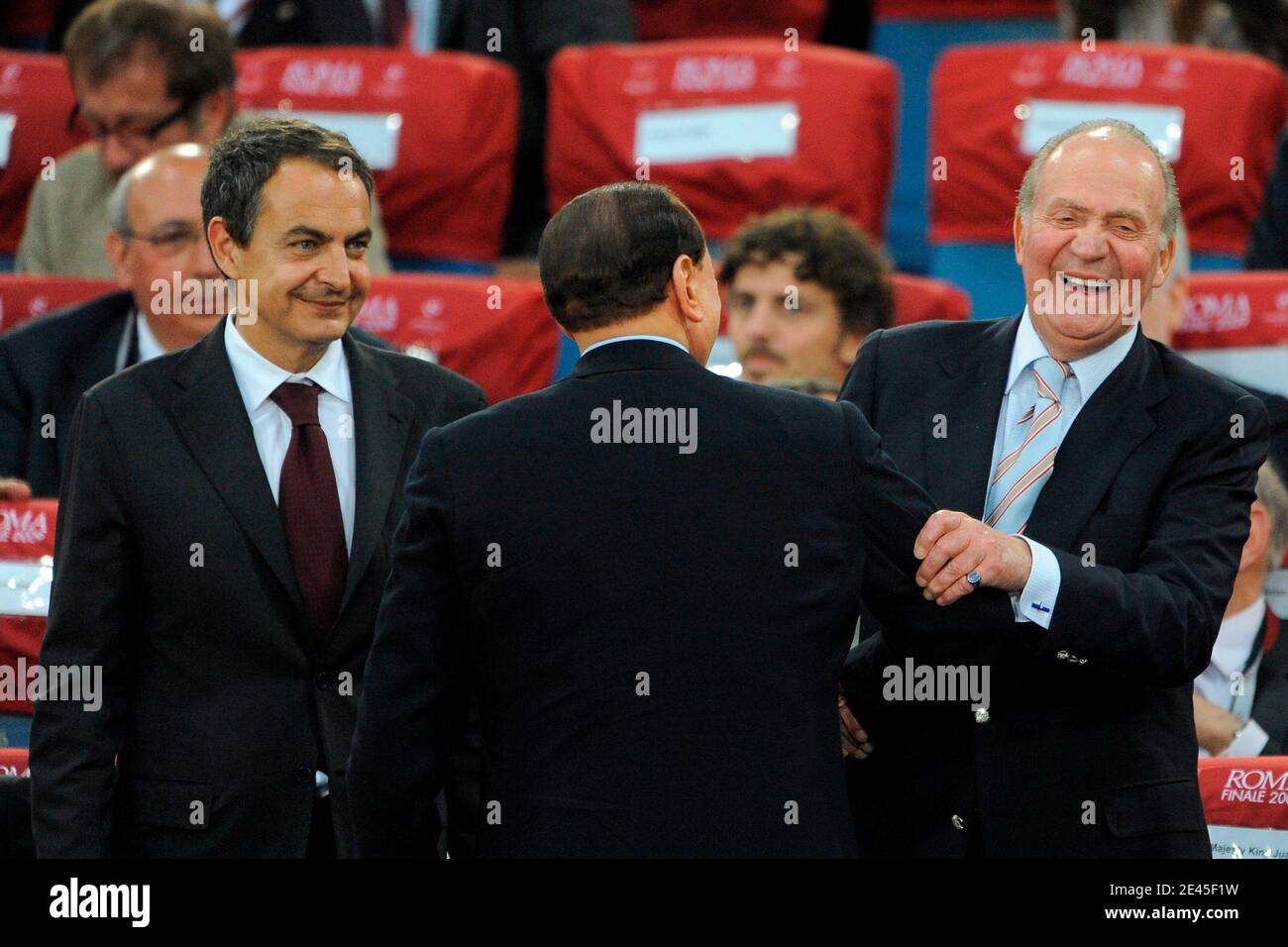 El primer ministro italiano Silvio Berlusconi (centro) habla con el rey  Juan Carlos de España y el presidente español José Luis Rodríguez Zapatero  en los stands antes del inicio del partido de