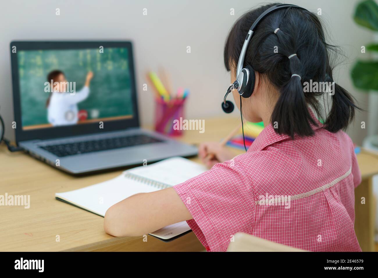 Video conferencia de estudiantes asiáticos e-learning con maestros y compañeros de clase en la computadora en la sala de estar en casa. Homeschooling y aprendizaje a distancia, en Foto de stock