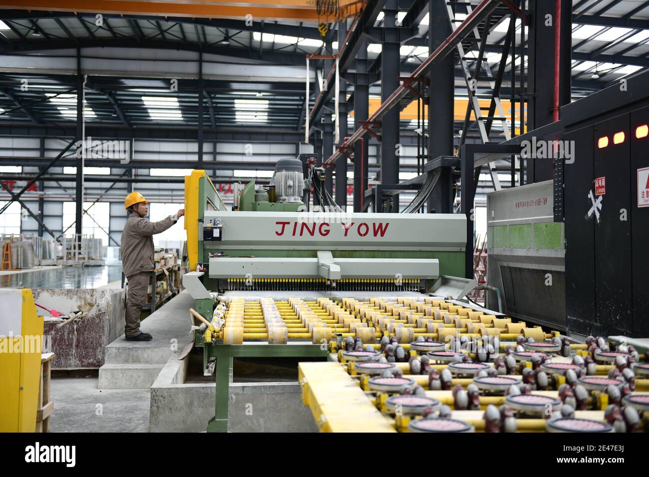 Un trabajador procesa piedras en una fábrica de piedra local, Qianxinan Buyei y la Prefectura Autónoma de Miao, al suroeste de China¯provincia de Guizhou, 21 de enero de 202 Foto de stock