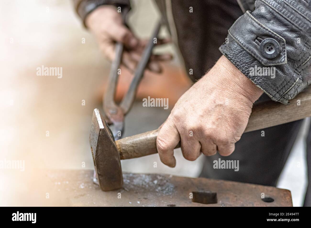 Un herrero forja una herradura sobre un yunque. Foto de stock