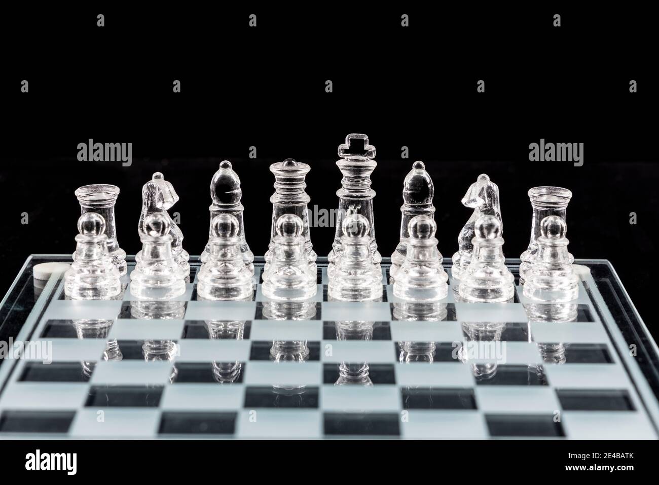 Piezas de ajedrez de vidrio sobre un tablero de ajedrez de vidrio con  reflejo, sobre fondo negro Fotografía de stock - Alamy
