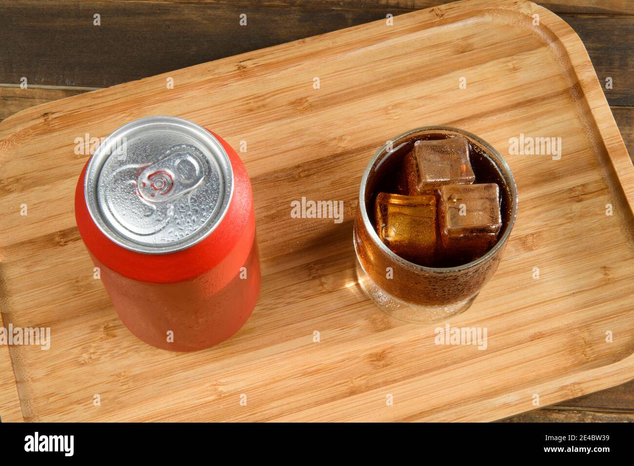Lata de soda con un vaso lleno de hielo y bebida en la bandeja de bambú  Fotografía de stock - Alamy