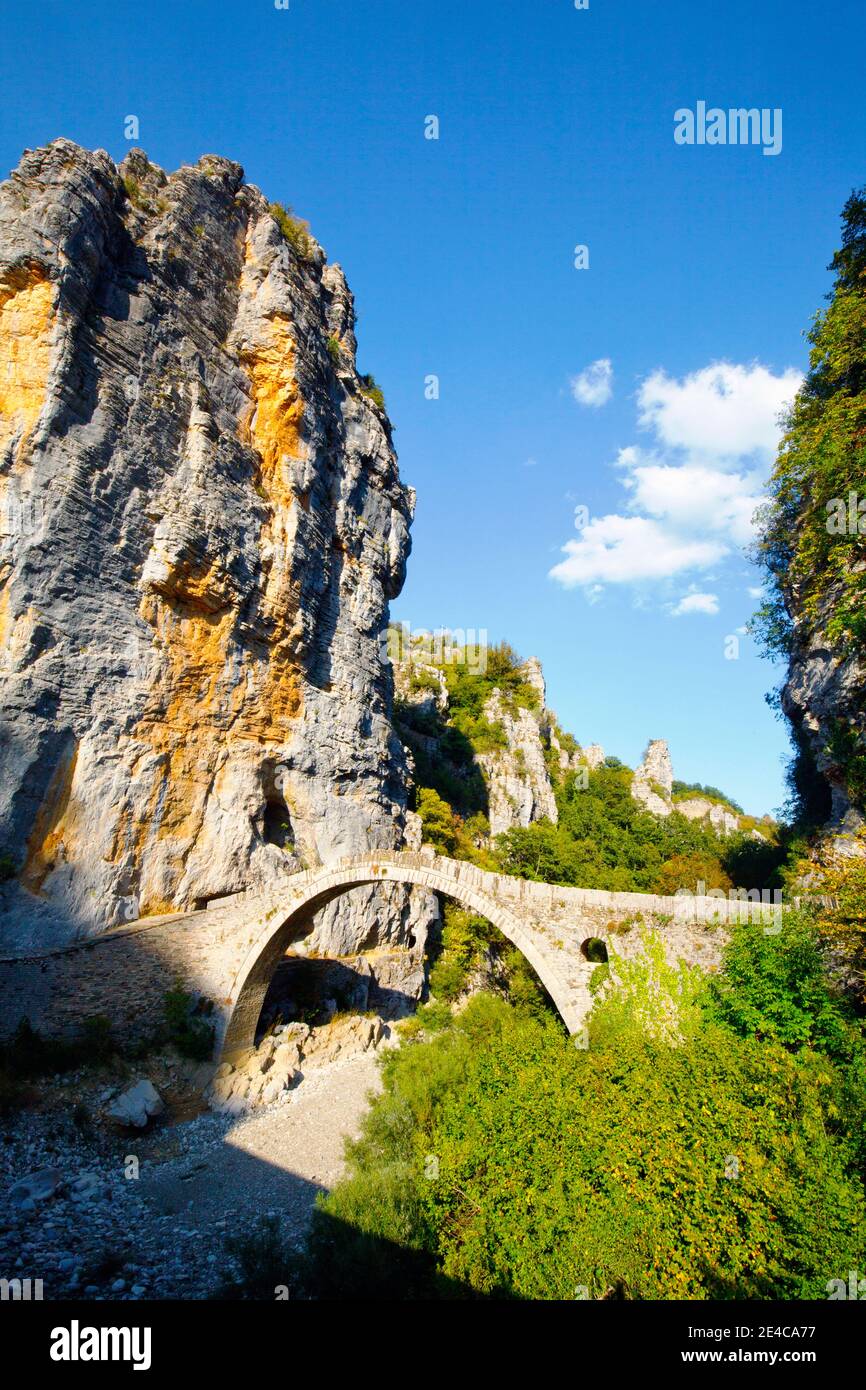 El puente de piedra Kokkoris de un solo arco fue construido en 1750, que abarca un estrecho valle de arroyo entre dos paredes empinadas, región montañosa de Epirus, al norte de Grecia Foto de stock