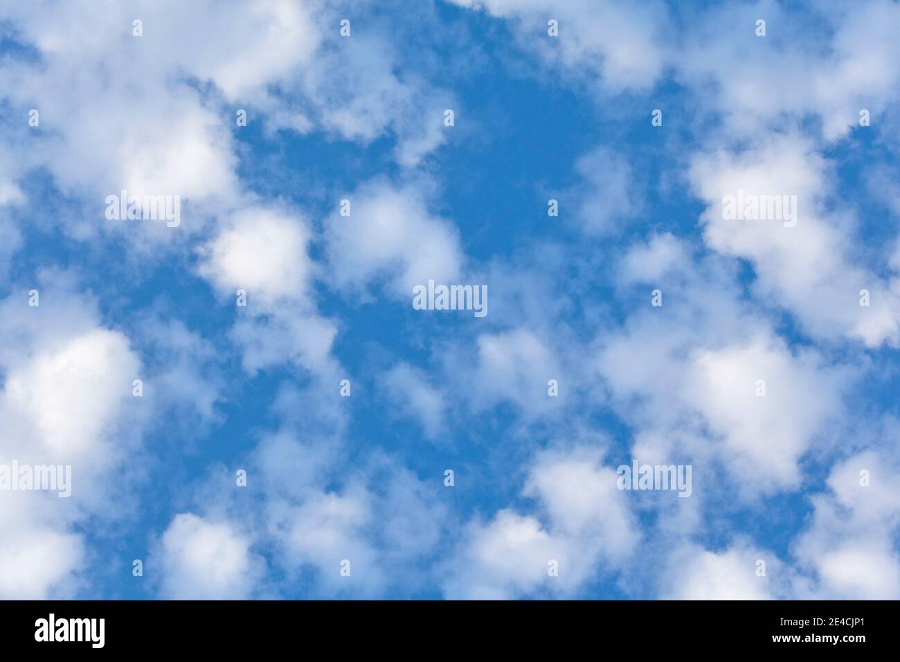 Las nubes manchadas contra un cielo azul profundo Foto de stock
