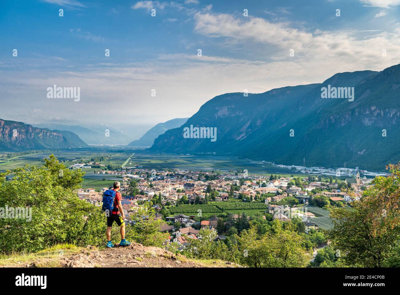 Montan, Provincia de Bolzano, Tirol del Sur, Italia. Un excursionista en el ascenso a la colina de Castelfeder, donde se encuentran rastros de prehistórico y alta colonia medieval. En el valle el pueblo de Auer Foto de stock