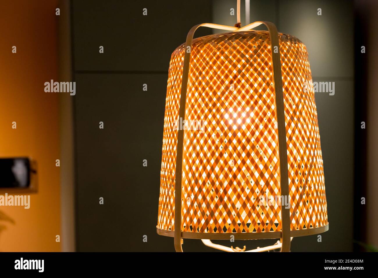 Decorando lámparas colgantes de en mimbre de madera hecho de bambú.Beige boho interior de la sala de estar, accesorios elegantes, caseta de ratán colgante en Fotografía de Alamy