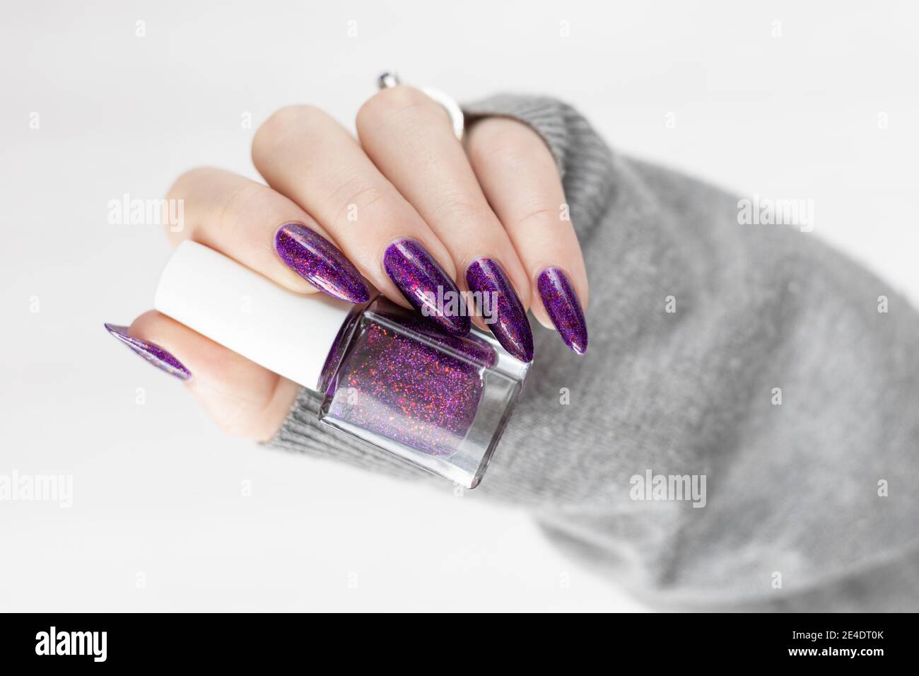 Manos de mujeres con uñas largas con esmalte de uñas violeta púrpura  Fotografía de stock - Alamy